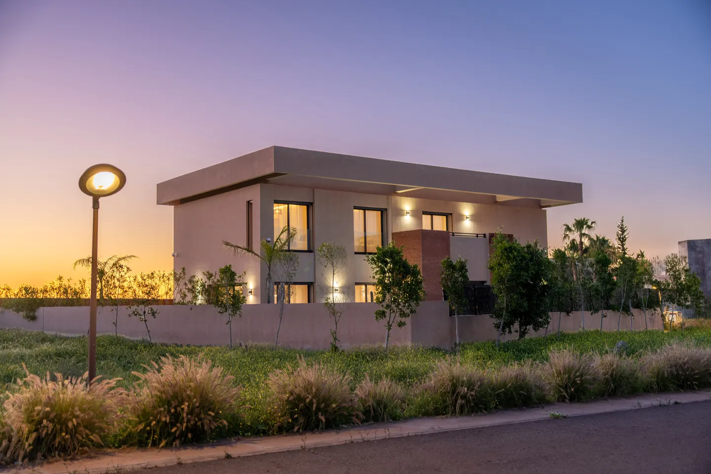 The villa's facade at sunset seen from the residence street