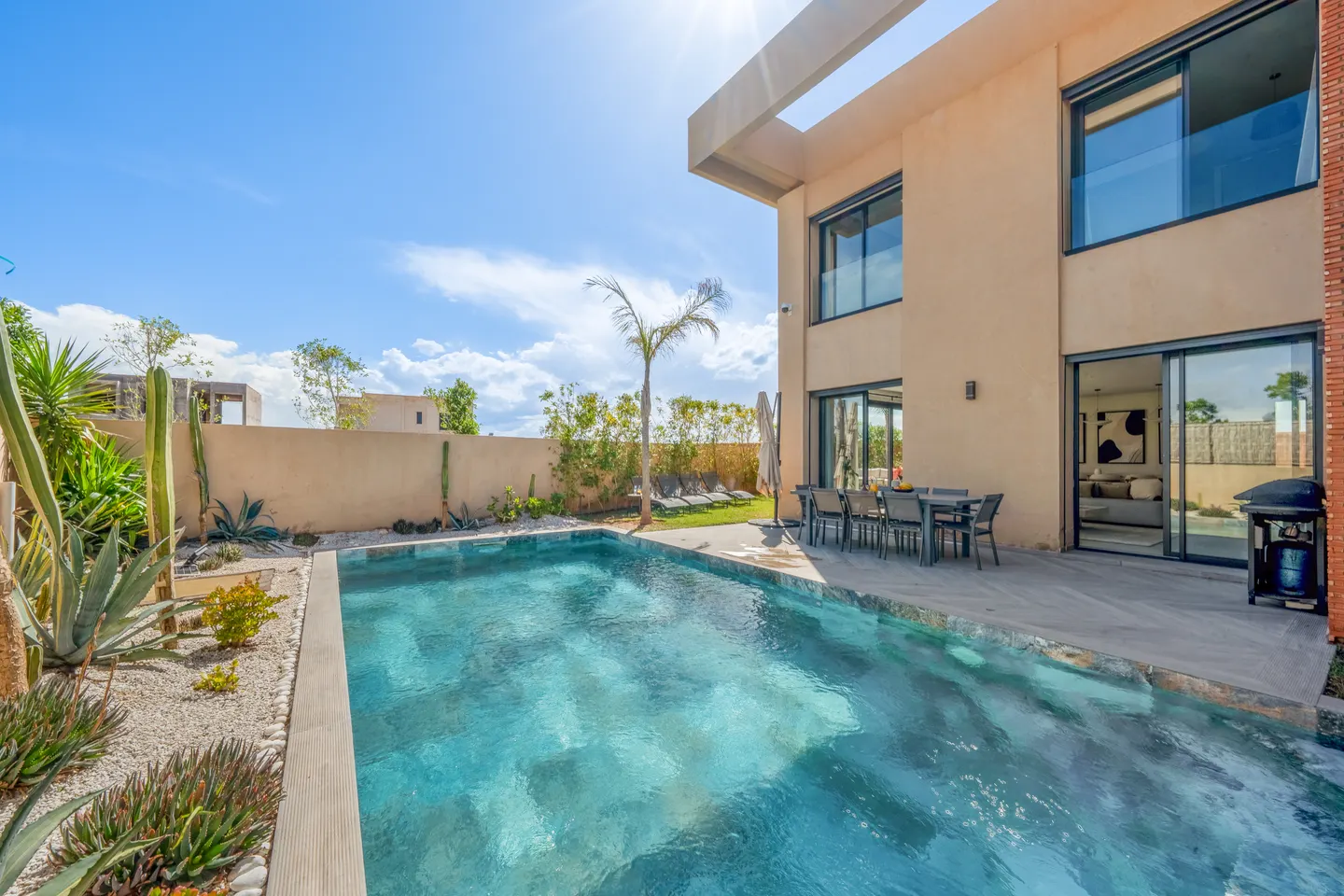 Pool along the villa's brick wall, dining terrace in the background