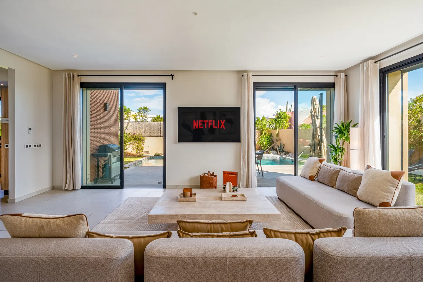 Living room, TV wall and glass doors to the pool