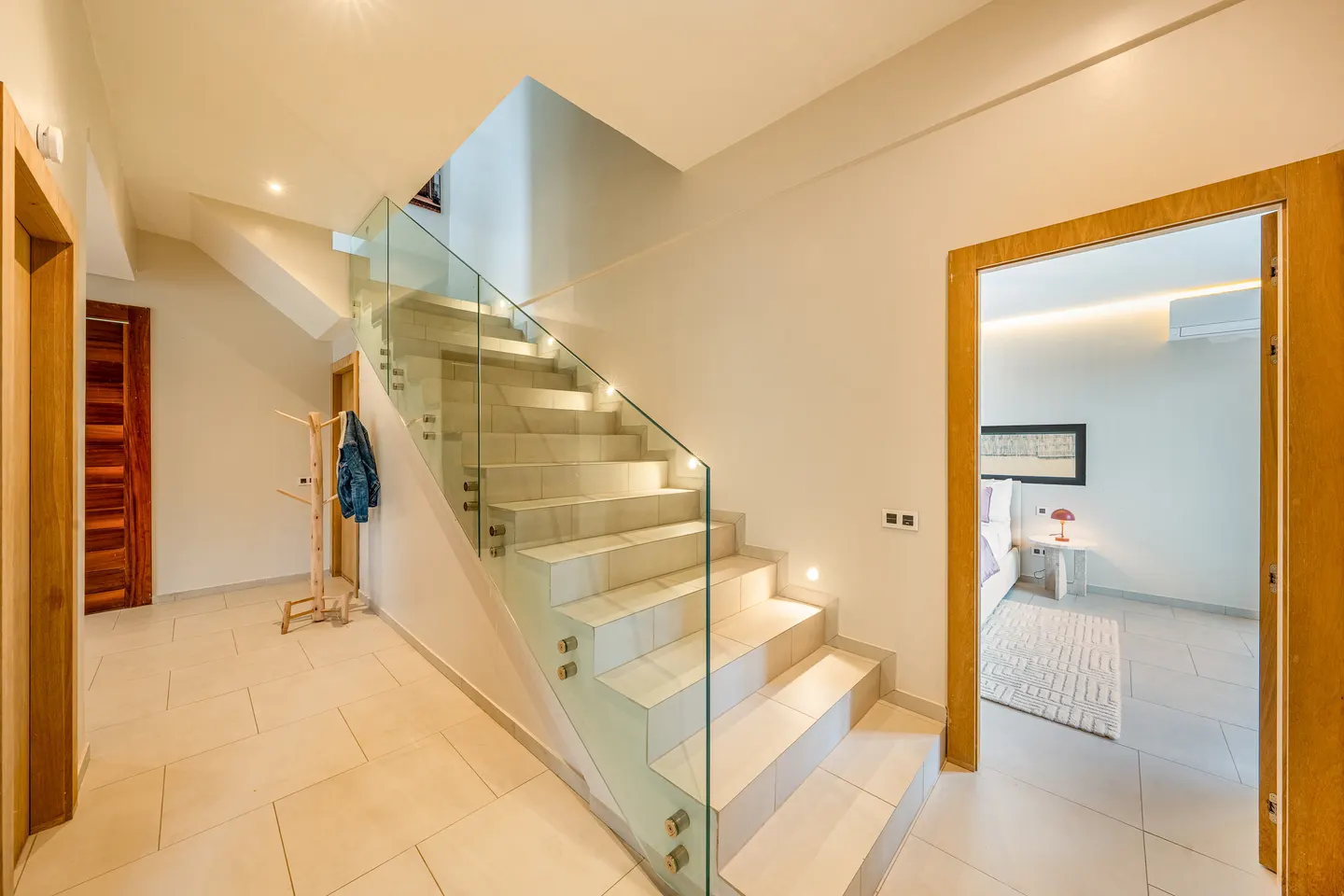Glass staircase and doorway to a bedroom
